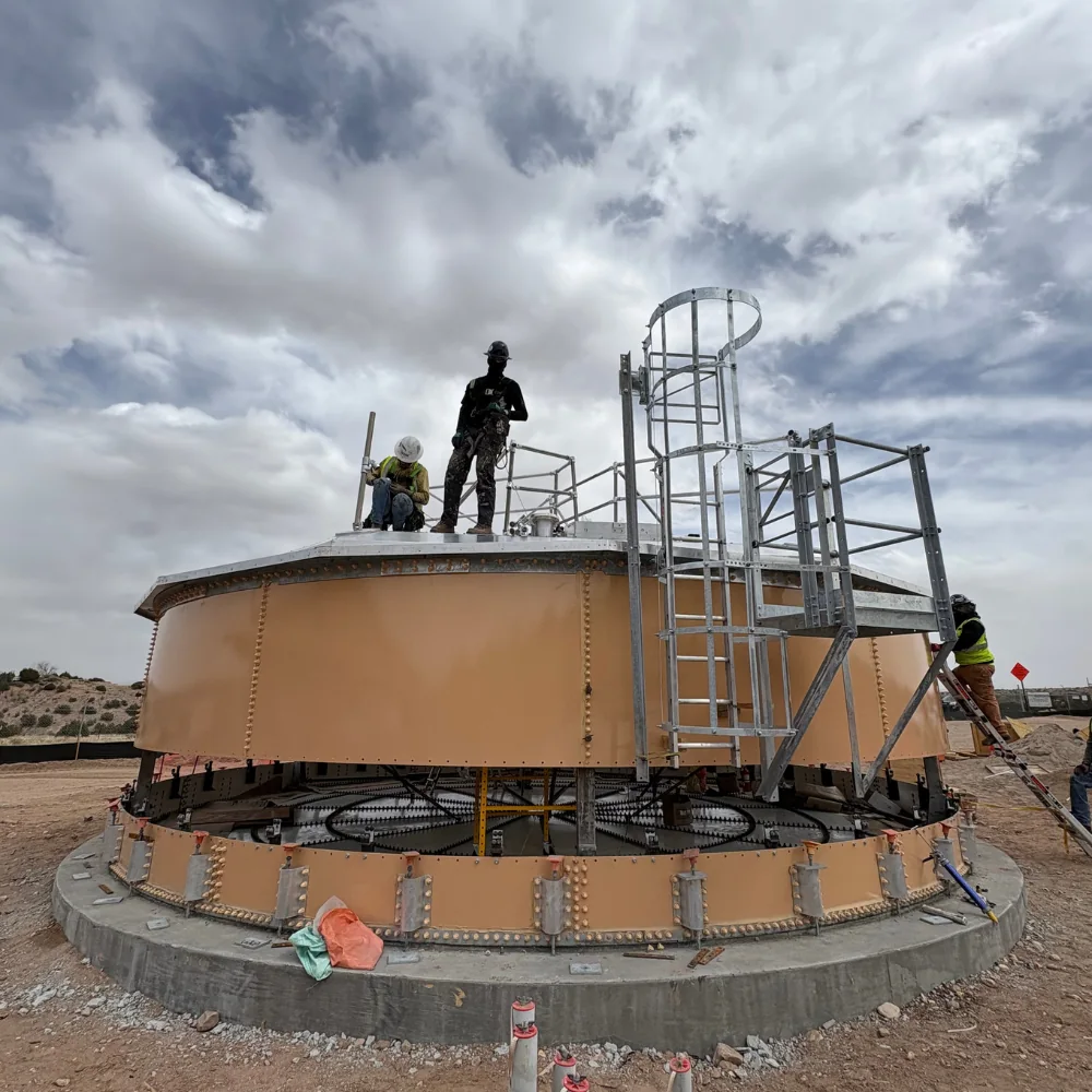 Crew performing field assembly on a factory-coated bolted steel flat-panel tank